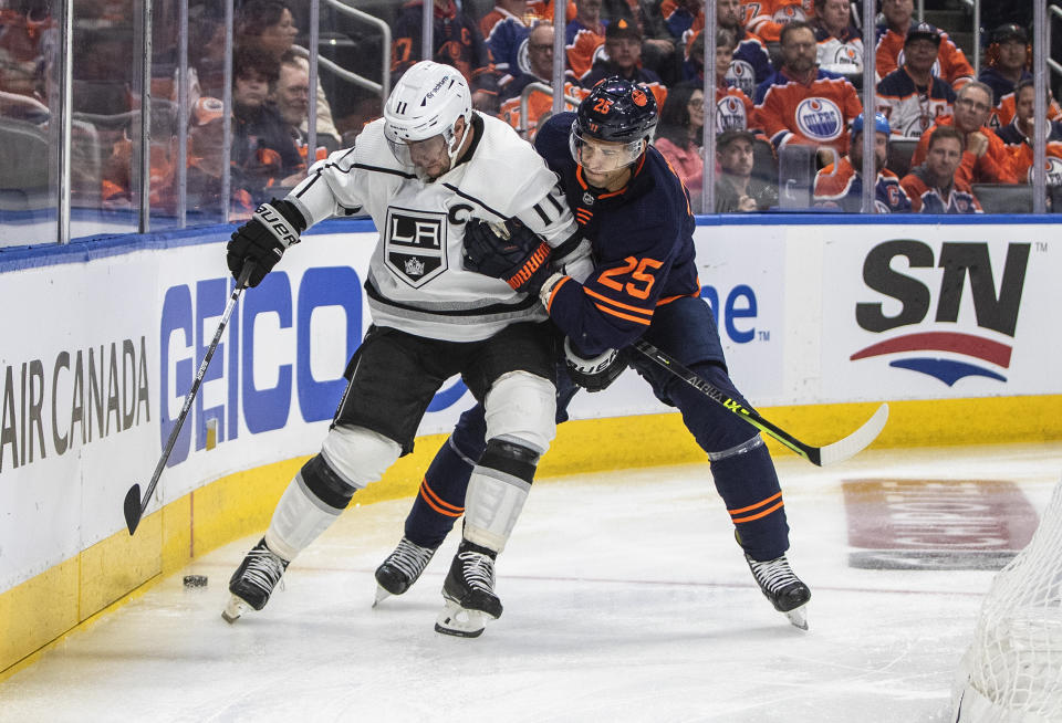 Los Angeles Kings' Anze Kopitar (11) and Edmonton Oilers' Darnell Nurse (25) battle for the puck during the third period of Game 1 of an NHL hockey Stanley Cup first-round playoff series, Monday, May 2, 2022 in Edmonton, Alberta. (Jason Franson/The Canadian Press via AP)