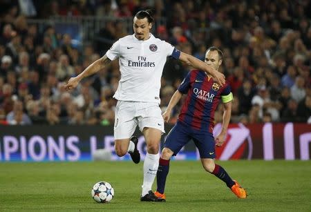 Football - FC Barcelona v Paris St Germain - UEFA Champions League Quarter Final Second Leg - Nou Camp, Barcelona - Spain - 21/4/15 PSG's Zlatan Ibrahimovic in action with Barcelona's Andres Iniesta Reuters / Paul Hanna