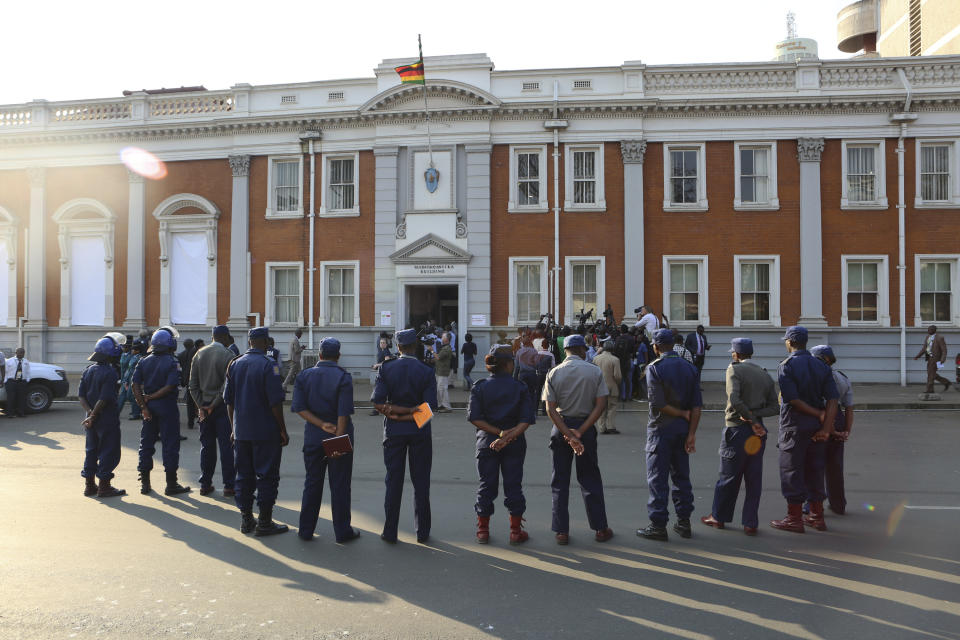 Police gather outside the Constitutional Court after the court upheld Zimbabwean President Emmerson Mnangagwa' s narrow victory in Harare, Friday, August, 24, 2018. Zimbabwe's constitutional court on Friday unanimously upheld President Emmerson Mnangagwa's narrow victory in last month's historic election after the opposition alleged vote-rigging, saying "sufficient and credible evidence" had not been produced. (AP Photo/Tsvangirayi Mukwazhi)