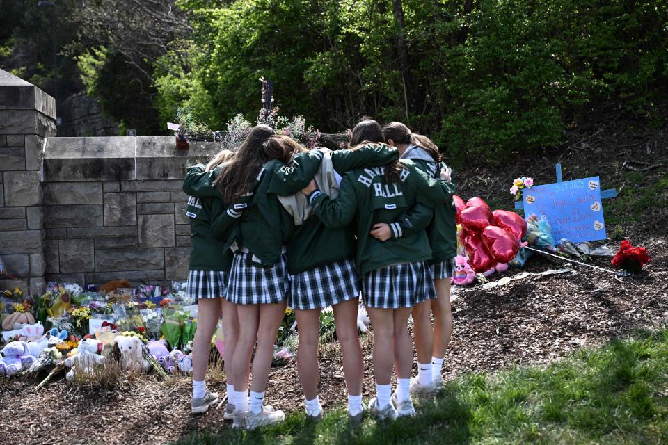 Students embrace in front of a makeshift memorial for the victims of a March 27 shooting at The Covenant School in Nashville, Tenn.