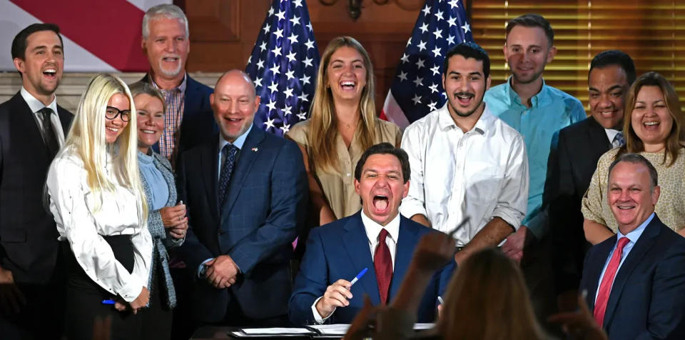 Gov. Ron DeSantis laughs during a May 2023 ceremony to sign bills banning diversity, equity and inclusion programs at Florida colleges and universities. He chose to sign it at New College of Florida, in Sarasota. At bottom right is then-Interim President Richard Corcoran, who was named New College's fulltime president in October 2023.