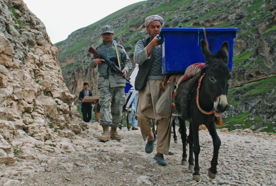 Afghan election workers use donkeys to transport ballot boxes and election materials to polling stations as walking through Mazar-i-Sharif to Kishindih district in Balkh province, Afghanistan, Thursday, April 3, 2014. Elections will take place on Saturday. (AP Photo/Mustafa Najafizada)