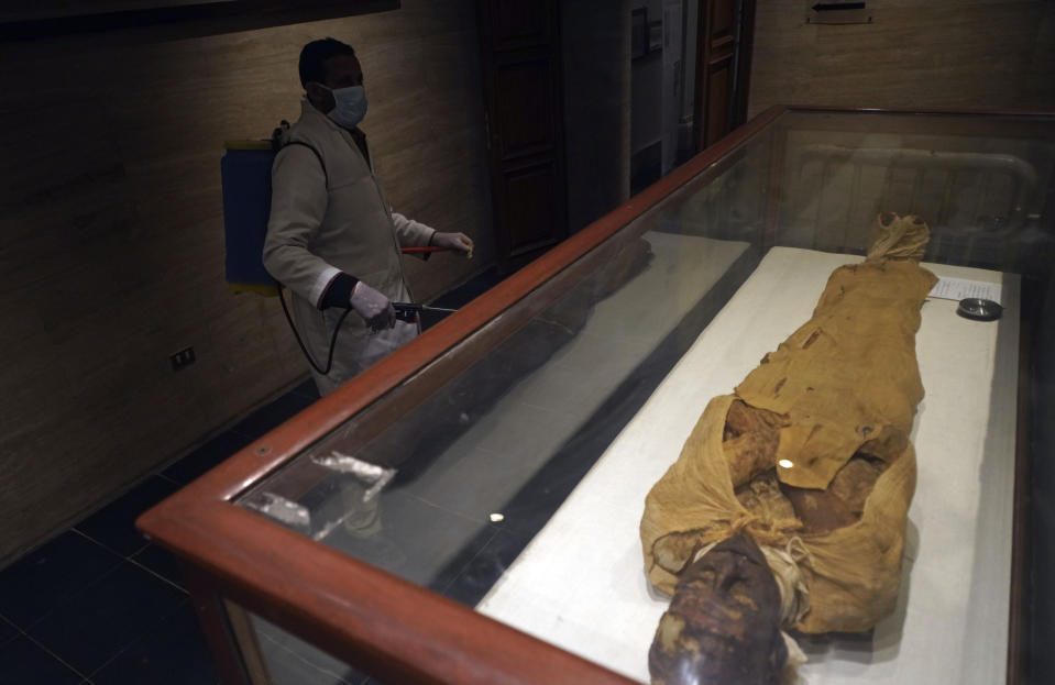 A worker disinfects in the hall of the Queens, in an effort to help prevent the spread of the coronavirus, at the Egyptian Museum in Tahrir Square, Cairo, Egypt, Monday, March 23, 2020. (AP Photo/Hamada Elrasam)