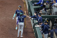 Seattle Mariners' J.P. Crawford (3) gives Julio Rodriguez a trident as they celebrate Rodriguez's two-run home run in the third inning of the team's baseball game against the Texas Rangers in Arlington, Texas, Tuesday, April 23, 2024. (AP Photo/Tony Gutierrez)