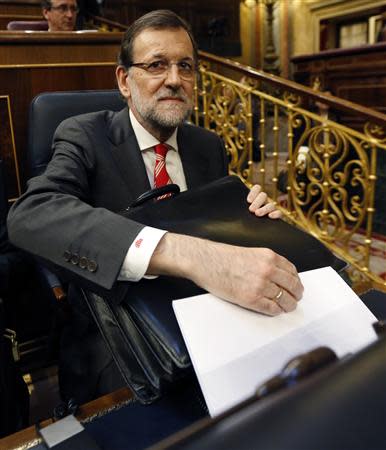 Spain's Prime Minister Mariano Rajoy holds documents as he takes his seat at Spanish Parliament in Madrid April 8, 2014. REUTERS/Sergio Perez