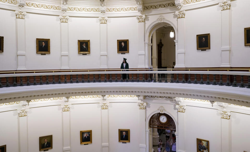 A graduate poses for family photos in the rotunda at the State Capitol, Tuesday, June 1, 2021, in Austin, Texas. The Texas Legislature closed out its regular session Monday, but are expected to return for a special session after Texas Democrats blocked one of the nation's most restrictive new voting laws with a walkout. (AP Photo/Eric Gay)