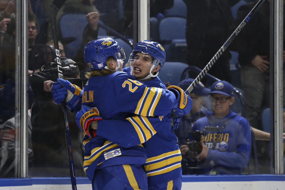 Buffalo Sabres defenseman Rasmus Dahlin (26) and center Dylan Cozens, right, celebrate after Cozens scored a goal during the third period of an NHL hockey game against the Tampa Bay Lightning, Monday, Nov. 28, 2022, in Buffalo, N.Y. (AP Photo/Joshua Bessex)