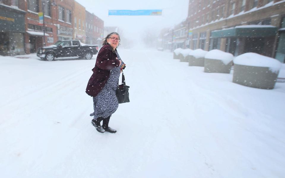 A pedestrian crosses the road on 6th Street during the winter storm on Friday, Jan. 12, 2024, in Ames, Iowa.