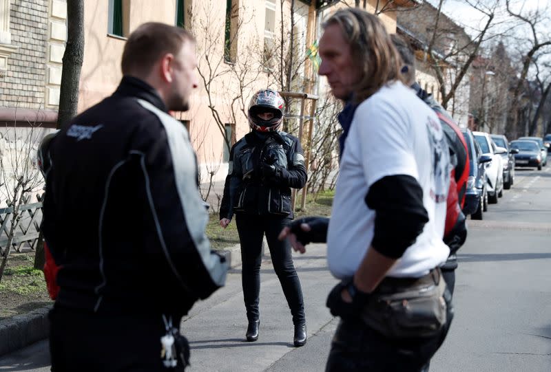 Members of the 'Easy Riders', a Hungarian bikers group, talk as they help a domestic violence victim in Budapest