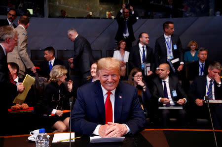 U.S. President Donald Trump attends a meeting of the North Atlantic Council during a NATO summit in Brussels, Belgium, July 11, 2018. Reuters photographer Francois Lenoir: "I like the contrast in the photograph. The presence of U.S. President Trump posing smiling and the lack of interest of the officials in the background." REUTERS/Francois Lenoir