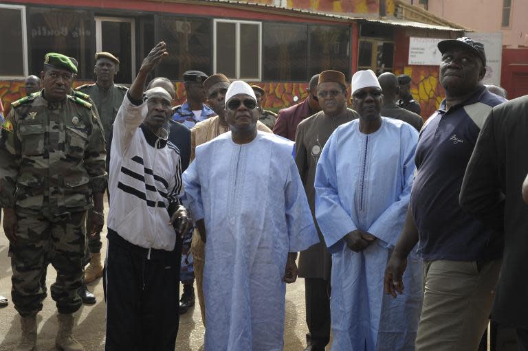 Mali's President Ibrahim Boubacar Keita (C) and Prime Minister Modibo Keita (2R) arrive to La Terrasse bar restaurant in Bamako on March 7, 2015, after five people were shot dead in an overnight suspected terror attack