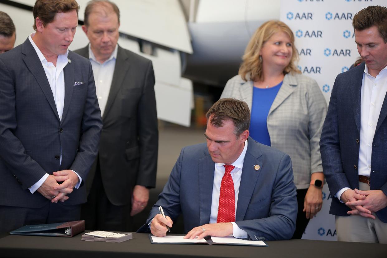 Gov. Kevin Stitt signs Senate Bill 621, which creates the Oklahoma Workforce Commission, during a Wednesday ceremony inside a hangar at Will Rogers World Airport in Oklahoma City.