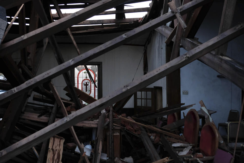 A stained glass window is visible across the sanctuary of the St. James African Methodist Episcopal Church on Jan. 9, 2022, in Mayfield, Ky. A tornado on Dec. 10, 2021, collapsed the auditorium roof and northern-facing wall. “We don’t have a building, but other churches within our denomination have been sending us supplies,” said Thomas Bright, steward at St. James AME, which suffered major damage to its roof and sanctuary. “So ... we got some U-Haul containers in our parking lot and we set up tables, so we’ve been distributing supplies, food, clothes, cleaning supplies, whatever we can to the community.” (AP Photo/Audrey Jackson)