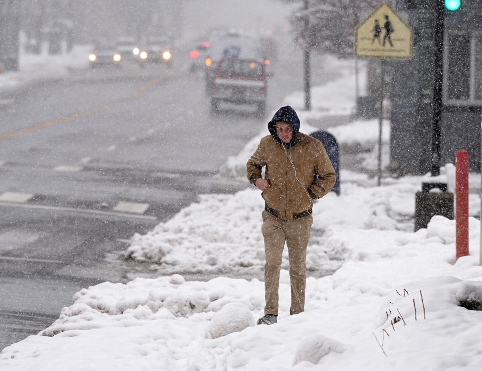 A pedestrian navigates a sidewalk packed with snow as a late winter storm regained force and resumed snowing late Thursday, March 14, 2024, in Denver. Forecasters predict that the storm, which has already dropped a foot or more of snow since starting Thursday morning, will persist until early Friday, snarling traffic along Colorado's Front Range communities. (AP Photo/David Zalubowski)