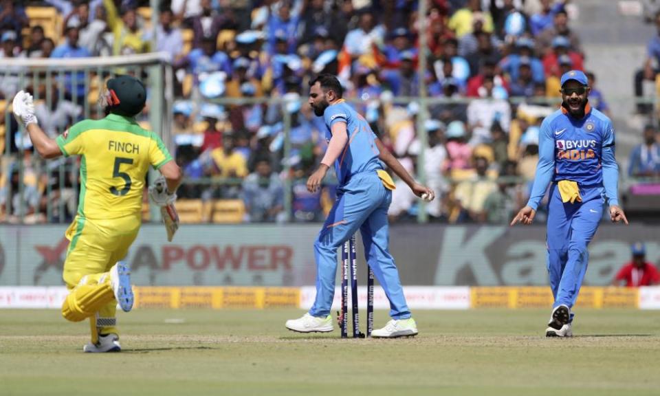 Virat Kohli (right) shows his delight after the comical mix-up cost Aaron Finch his wicket