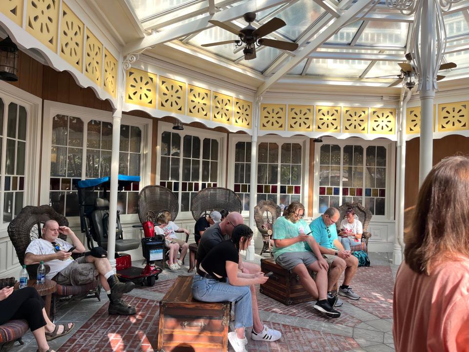 people sitting around the outdoor waiting area at skipper canteen in magic kingdom