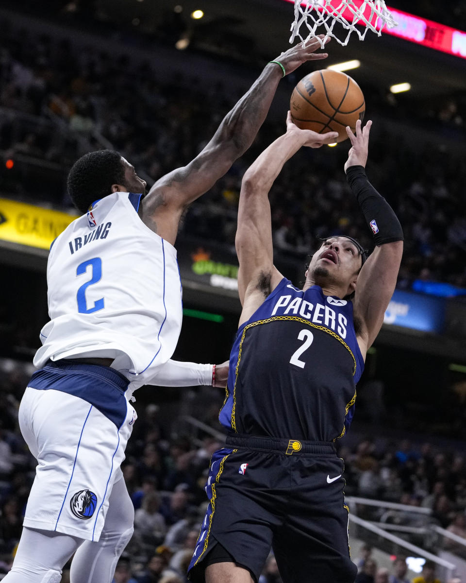 Indiana Pacers guard Andrew Nembhard (2) shoots over Dallas Mavericks guard Kyrie Irving (2) during the second half of an NBA basketball game in Indianapolis, Monday, March 27, 2023. The Mavericks defeated the Pacers 127-104. (AP Photo/Michael Conroy)