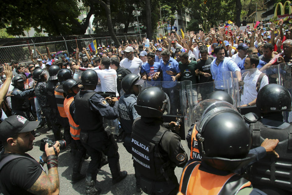 Demonstrators confront a cordon of Venezuelan National Police officer who temporarily block members of the opposition from reaching a rally against the government of President Nicolas Maduro in Caracas, Venezuela, Saturday, March 9, 2019.(AP Photo/Fernando Llano)