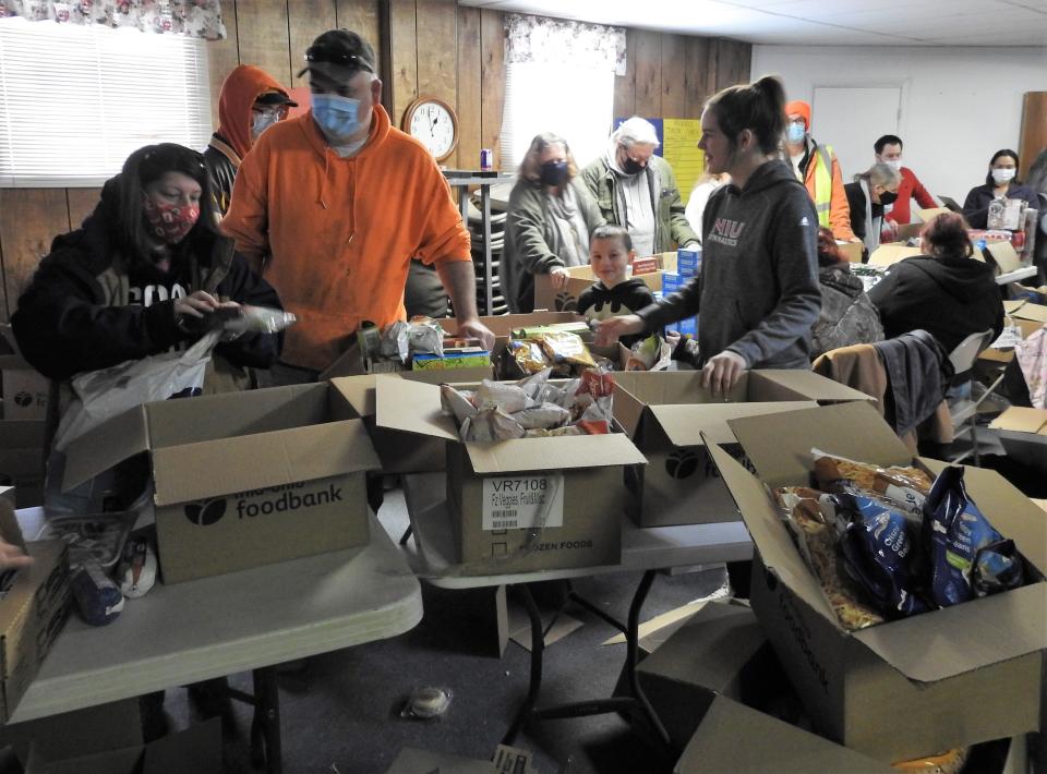 Individuals go through the basement of the Upper Room Assembly and Worship Center selecting food from the church's pantry. The church is seeking funds for a permanent building to house the pantry and provide easy drive-thru access.