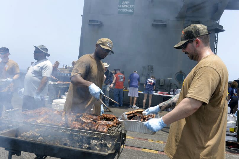 In this June 6, 2020, photo provided by the U.S. Navy, sailors participate in a steel beach picnic on the flight deck of the aircraft carrier USS Dwight D. Eisenhower (CVN 69)