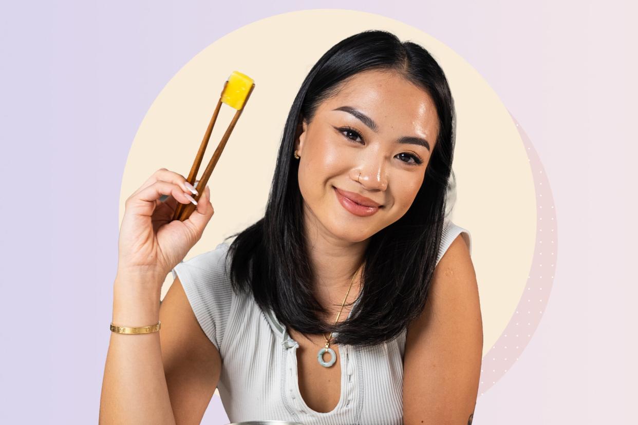 a photo of Tway Nguyen holding chopsticks with a piece of pineapple inbetween them