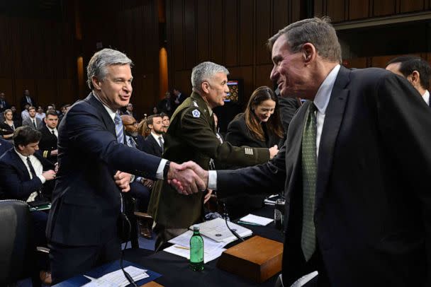 PHOTO: FBI Director Christopher Wray shakes hands with Senator and Senate Intelligence Committee Chair, Mark Warner, before a hearing on worldwide threats, in Washington, D.C., on March 8, 2023. (Mandel Ngan/AFP via Getty Images)