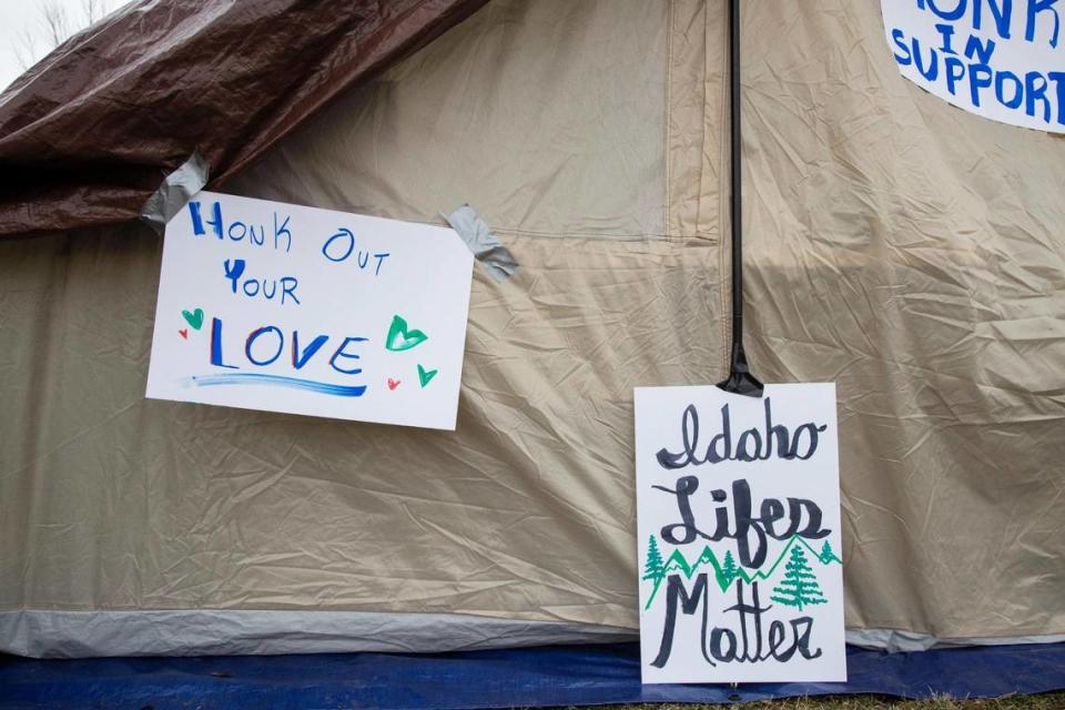 Signs made by homeless people holding a protest in downtown Boise hang from a tent on Tuesday.
