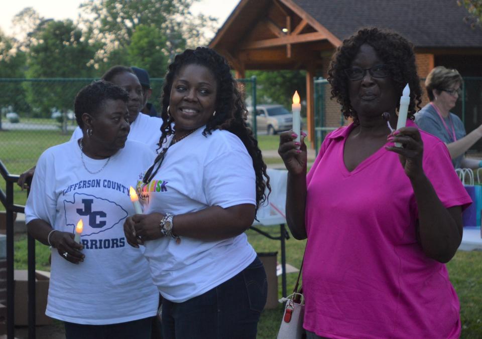 Survivors light candles at the event.