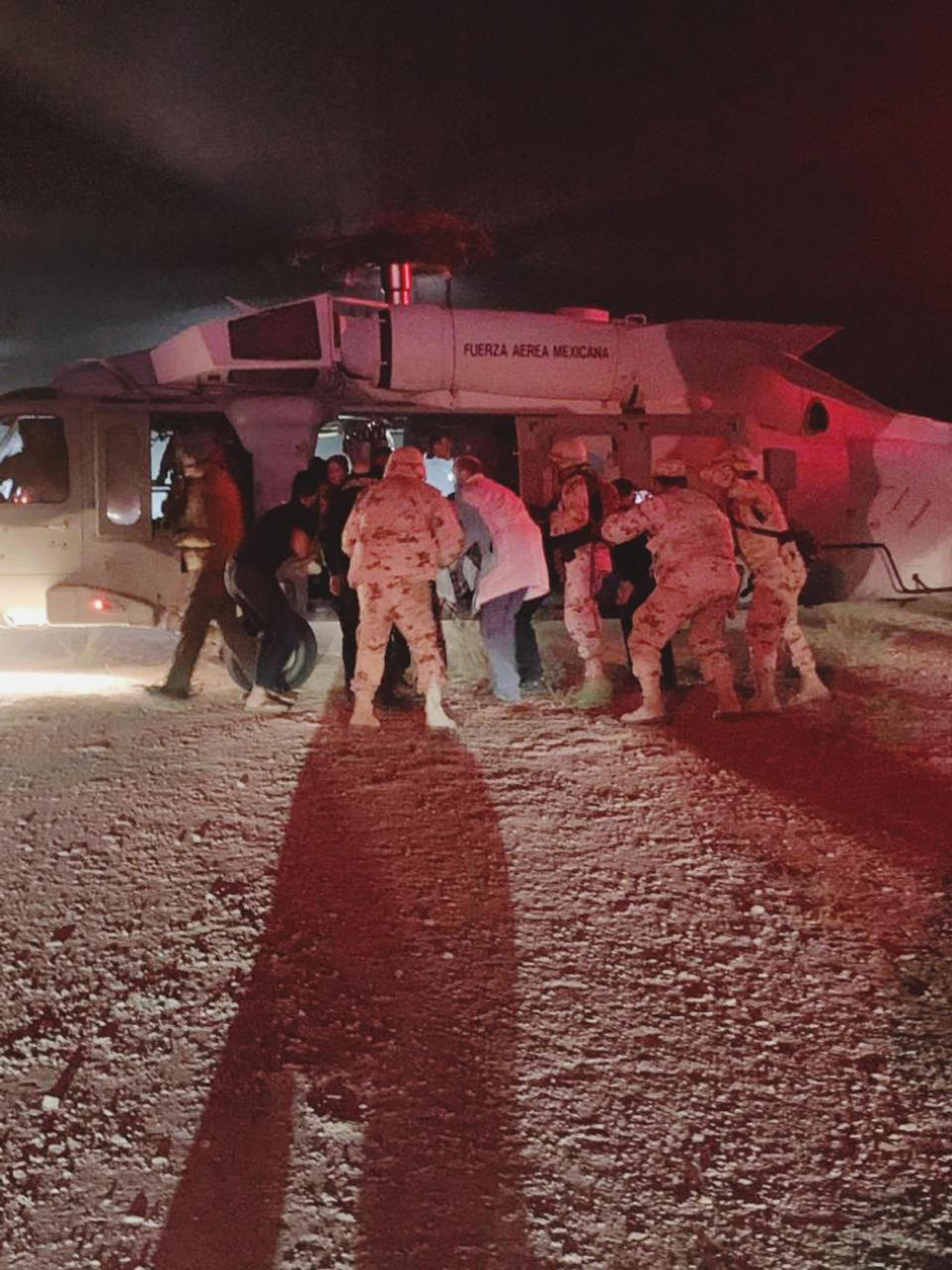 In this photo provided by the Sonora state Health Secretary, children of the extended LeBaron family, who were injured in an ambush are taken aboard a Mexican Airforce helicopter to be flown to the Mexico-U.S. border, from the border between the Mexican states of Chihuahua and Sonora, Monday, Nov.4, 2019. The children were injured when drug cartel gunmen ambushed three SUVs along a dirt road, slaughtering six children and three women, all U.S. citizens living in northern Mexico, in a grisly attack that left one vehicle a burned-out, bullet-riddled hulk. (Sonora state Health Secretary via AP)