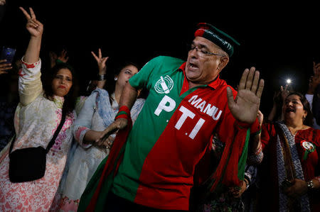 A supporter of cricket star-turned-politician Imran Khan, chairman of Pakistan Tehreek-e-Insaf (PTI), reacts to party songs with others, as they celebrate a day after the general election in Karachi, Pakistan July 26, 2018. REUTERS/Akhtar Soomro