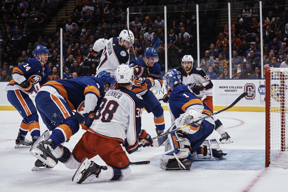 Columbus Blue Jackets' Josh Anderson (77) scrambles for the puck with New York Islanders' Ryan Pulock (6) during the first period of an NHL hockey game Saturday, Dec. 1, 2018, in Uniondale, N.Y. (AP Photo/Andres Kudacki)