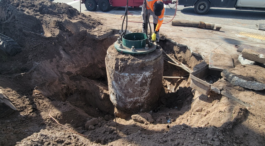 A worker tries to remove a foundation at the intersection of Atlantic Avenue and Lyons Road that is buried so deep into the ground that only the top part can be removed. State officials approved a county request to leave part of it buried or else the work at the intersection would have undergone another delay.
