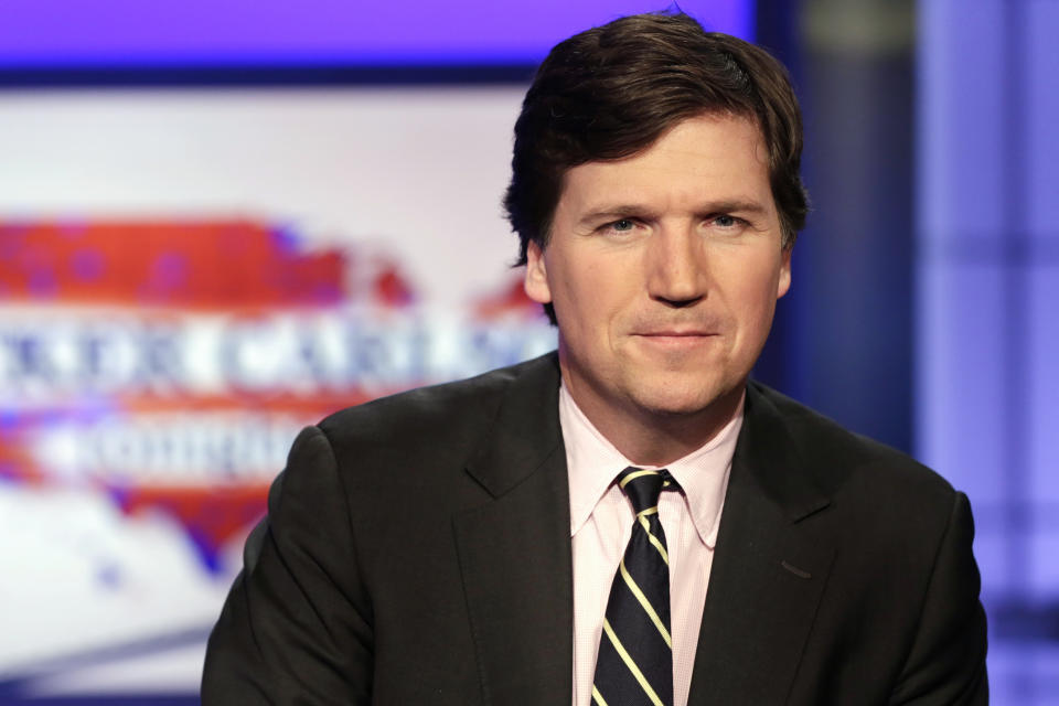 FILE - Tucker Carlson, host of "Tucker Carlson Tonight," poses for photos in a Fox News Channel studio on March 2, 2017, in New York. A racist text message from Tucker Carlson is what helped drive the commentator's ouster from Fox News, The New York Times reports. The Times says that in a text uncovered as part of a recent defamation lawsuit, the former Fox host lamented how supporters of former President Donald Trump ganged up to beat a protester. “It's not how white men fight,” Carlson wrote. (AP Photo/Richard Drew, File)