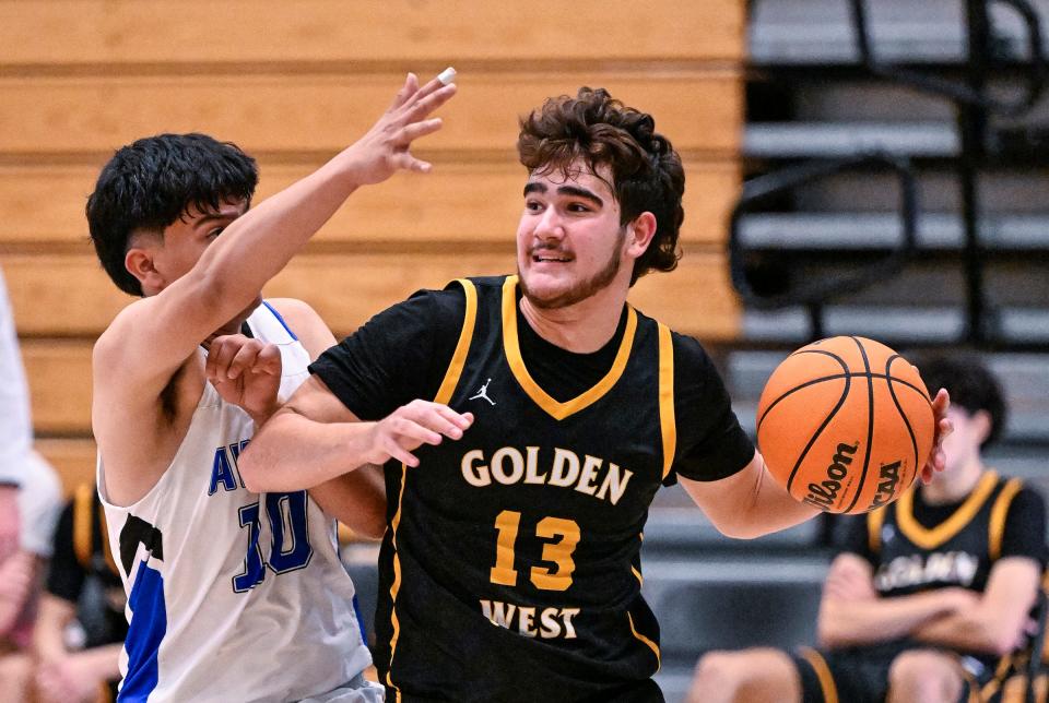 Golden West's Jagar Brooks looks to pass against Avenal's Rudy Ochoa in the Gonzalo Carrasco Memorial Varsity Boys Basketball Tournament at Reedley High School on Friday, January 5, 2024.