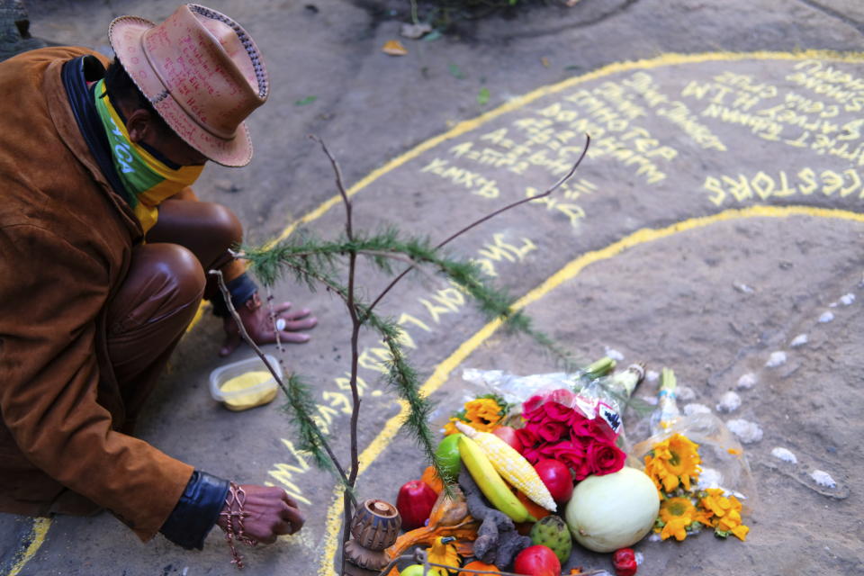 Paul Gentles, a Jamaican artist and member of the Rastafari faith, uses cornmeal to decorate an offering of fruits and flowers during a drumming circle at Brooklyn’s Prospect Park on Sunday, Oct. 24, 2021. As public opinion and policy continues to shift across the world toward the medicinal and recreational use of cannabis, some Rastafari adherents are questioning their place in the legal market of the herb that they consider sacred. (AP Photo/Luis Andres Henao)