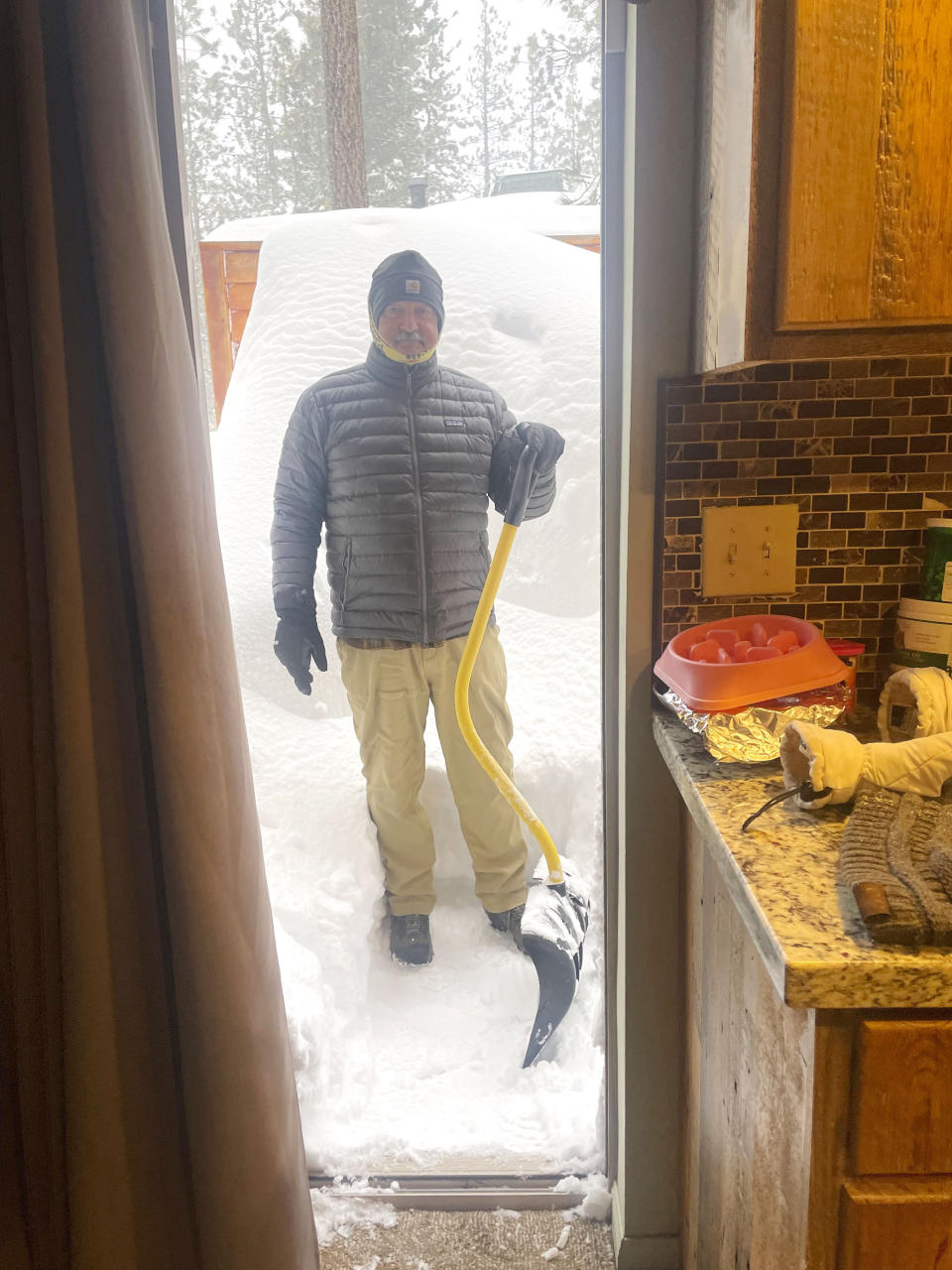 David and Kelli Góra dig out from a snowstorm that struck their home in Big Bear Lake, Calif., on Wednesday, March 1, 2023. (David Góra via AP)