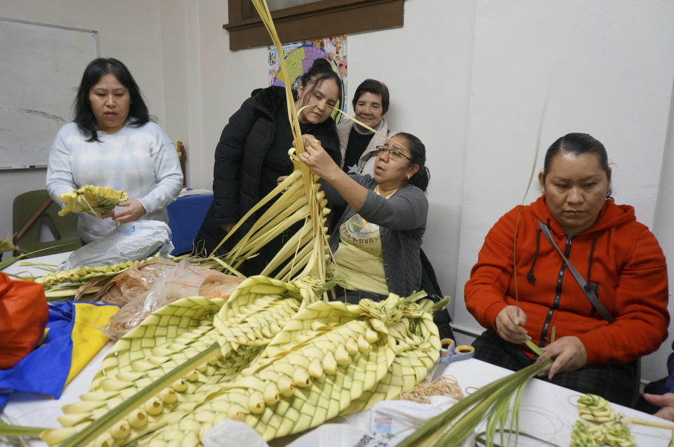 Isabel Tenorio, center holding palm, teaches how to weave palm fronds into elaborate designs to volunteers at the Church of the Incarnation in anticipation of Palm Sunday in Minneapolis on Wednesday, March 29, 2023. Volunteers said the traditional Mexican craft was harder than they thought, but important to practice and transmit to younger generations to keep both faith and culture alive. (AP Photo/Giovanna Dell’Orto)