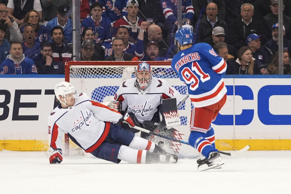 Washington Capitals' Nicolas Aube-Kubel, left, and goaltender Charlie Lindgren stops a shot by New York Rangers' Alex Wennberg during the first period in Game 2 of an NHL hockey Stanley Cup first-round playoff series, Tuesday, April 23, 2024, in New York. (AP Photo/Frank Franklin II)