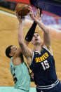 Denver Nuggets center Nikola Jokic, right, is fouled by Charlotte Hornets forward P.J. Washington during the first half of an NBA basketball game on Tuesday, May 11, 2021, in Charlotte, N.C. (AP Photo/Chris Carlson)