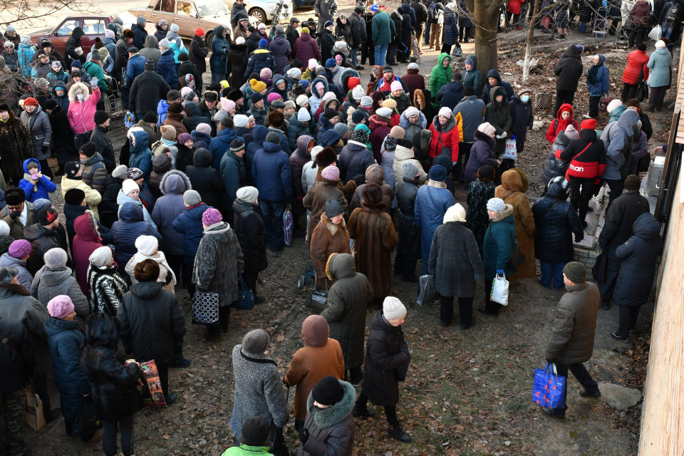 People wait to receive food at a humanitarian aid distribution spot in Kramatorsk, Ukraine, Wednesday, Dec. 7, 2022. (AP Photo/Andriy Andriyenko)