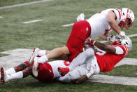 Nebraska linebacker JoJo Domann, top, and defensive back Marquel Dismuke, left, tackle Ohio State receiver Garrett Wilson during the first half of an NCAA college football game Saturday, Oct. 24, 2020, in Columbus, Ohio. (AP Photo/Jay LaPrete)