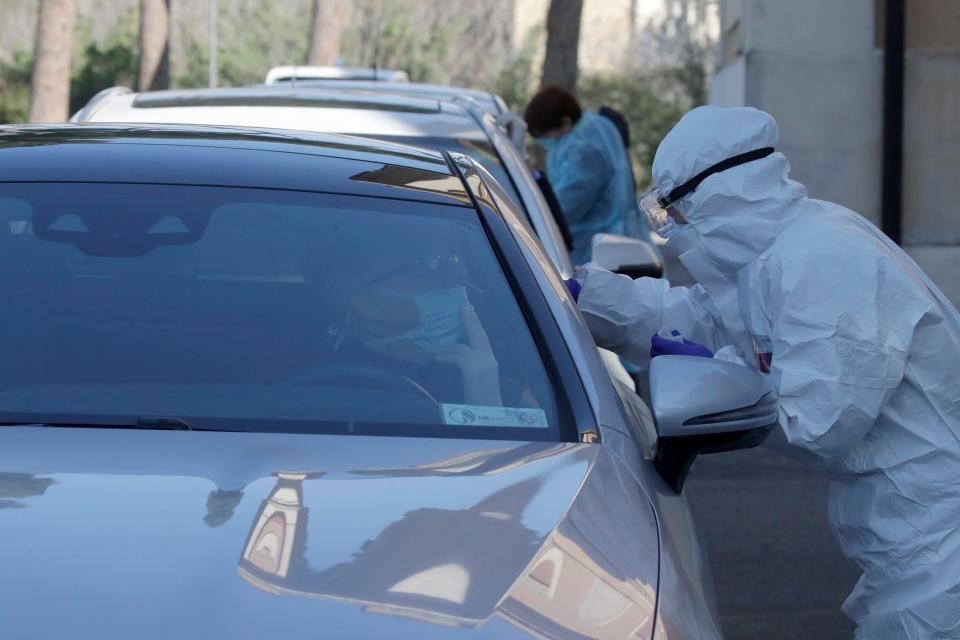 Medical staff of a mobile unit take samples from people in cars to test for Covid-19 at a drive-through position at the Santa Maria della Pieta' hospital complex, in Rome, Friday, April 3, 2020.