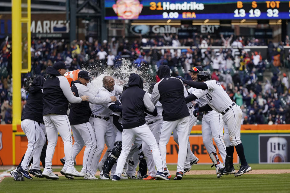 Detroit Tigers surround Javier Baez he hit a walk-off single during the ninth inning of a baseball game against the Chicago White Sox, Friday, April 8, 2022, in Detroit. (AP Photo/Carlos Osorio)