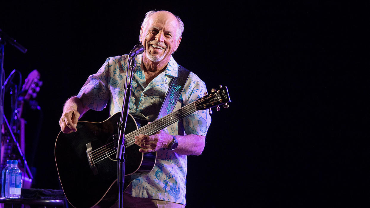  Jimmy Buffett playing guitar onstage in 2021 