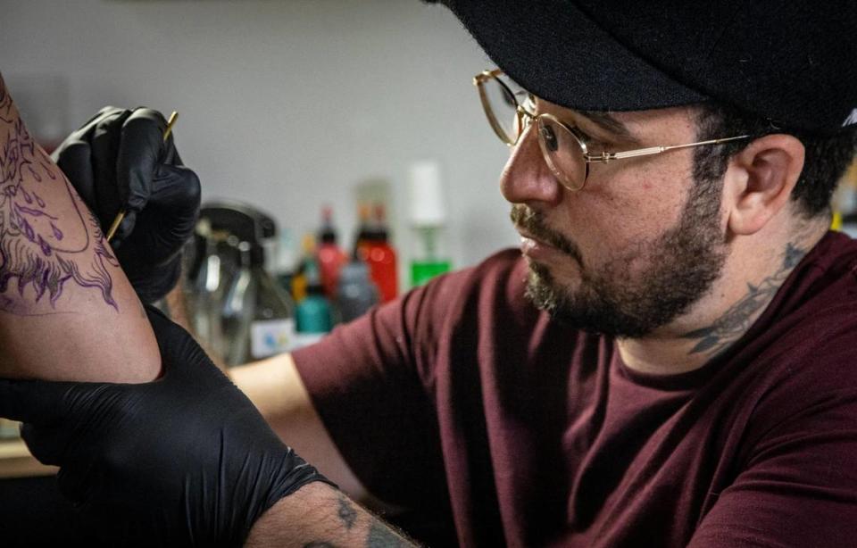 Javier Betancourt trabaja en una pieza en su estudio de tatuajes Ocho Placas, dentro de White Rose Coffee.