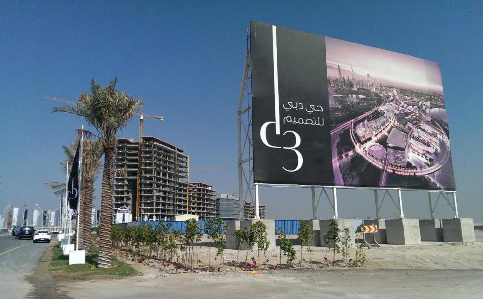 In this Jan. 30, 2014 photo, with a billboard showing the Dubai Design District, construction work is being carried at the project site in Dubai, United Arab Emirates. Dubai and luxury are nearly synonymous. The city is home to the world’s tallest tower, massive manmade islands in the shape of palm trees and a fleet of police cars that include a Ferrari, Lamborghini and a $2.5 million Bugatti Veyron. To boost its glamour factor and economy, the city has its eyes set on the multi-billion dollar a year global fashion industry, which is currently dominated by the U.S., Europe and Japan. (AP Photo/Aya Batrawy)