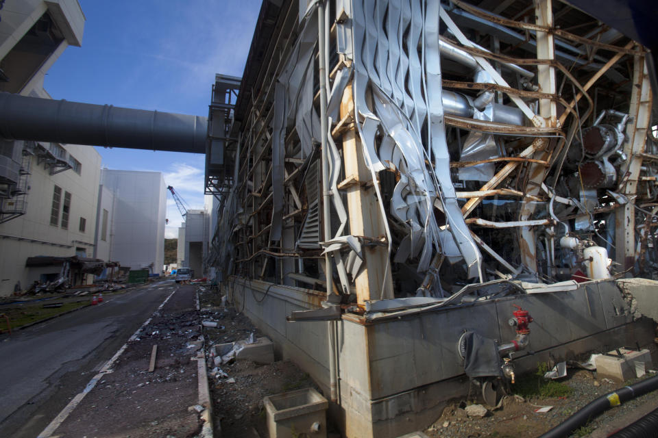 FILE - In this Nov. 12, 2011 file photo, the crippled Fukushima Daiichi nuclear power station is seen through a bus window in Okuma, Japan, as the media were allowed into Japan's tsunami-damaged nuclear power plant for the first time since the March 11 disaster. A decade ago, the Fukushima Daiichi nuclear power plant melted down. It looked like a bombed-out factory in a war zone. Emergency workers risked their lives as they battled to keep the crisis in check. Eeriness is no longer there. The feeble-looking plastic hoses mended with tape and the outdoor power switchboard that rats got into, causing blackouts, were replaced with proper equipment. (AP Photo/David Guttenfelder, Pool, File)