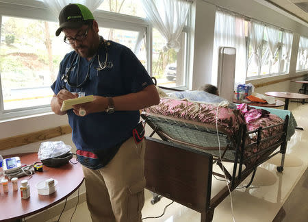 Dr. Carlos Mellado reviews prescriptions of patients in a public shelter in Orocovis, Puerto Rico, on October 3, 2017. REUTERS/Robin Respaut