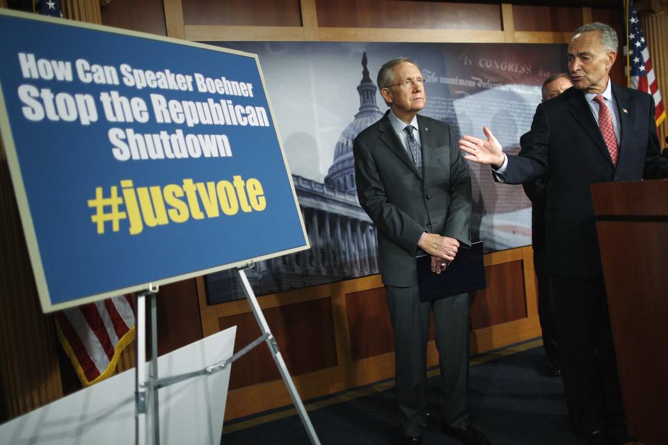 U.S. Senator Charles Schumer (R) and Senate Majority Leader Harry Reid (2nd R) refer to a Democratic social media hashtag to pressure House Speaker John Boehner (not pictured) for a vote on a budget free of measures related to the shutdown as they address reporters at the U.S. Capitol in Washington, October 3, 2013. U.S. Senate Democrats will insist on "clean" bills to raise the federal debt limit and restore government funding that are free of conditions, Reid said on Thursday. REUTERS/Jonathan Ernst (UNITED STATES - Tags: POLITICS ELECTIONS BUSINESS)