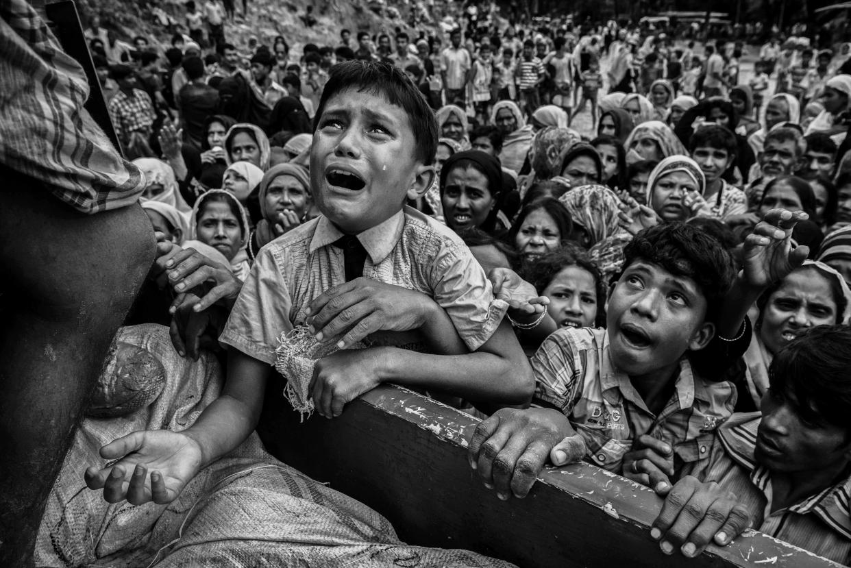 A Rohingya refugee boy desperate for aid cries as he climbs on a truck distributing aid for a local NGO near the Balukali refugee camp on Sept. 20 in Bangladesh. (Photo: Kevin Frayer via Getty Images)